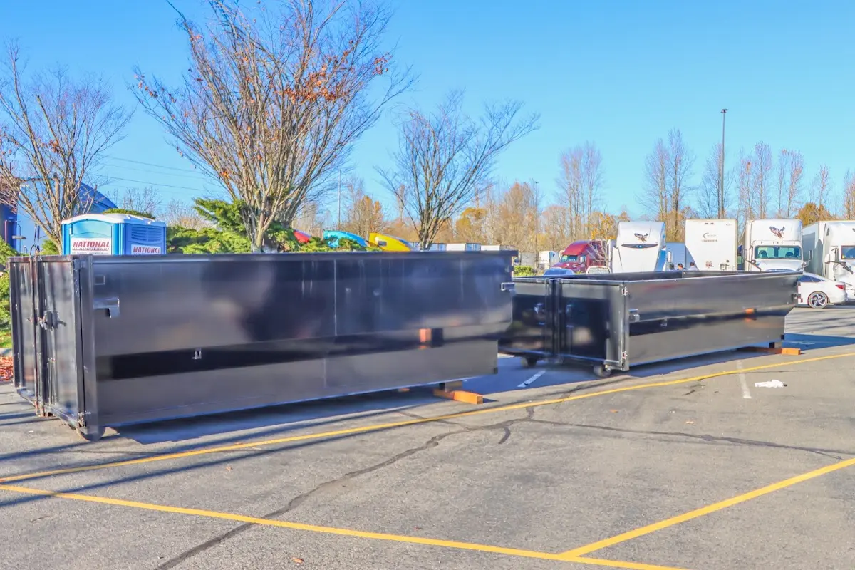 Professional dumpster rental service with roll-off container on residential driveway in Boulder